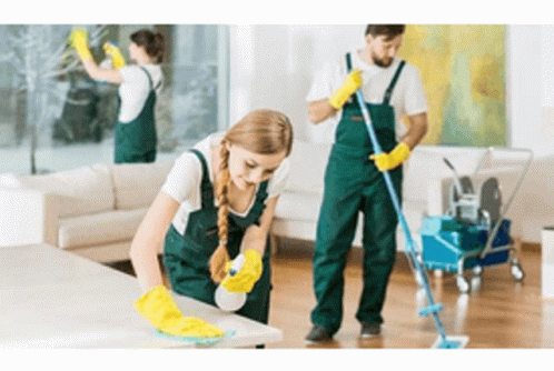 A uniformed cleaning crew wiping surfaces and mopping a commercial space